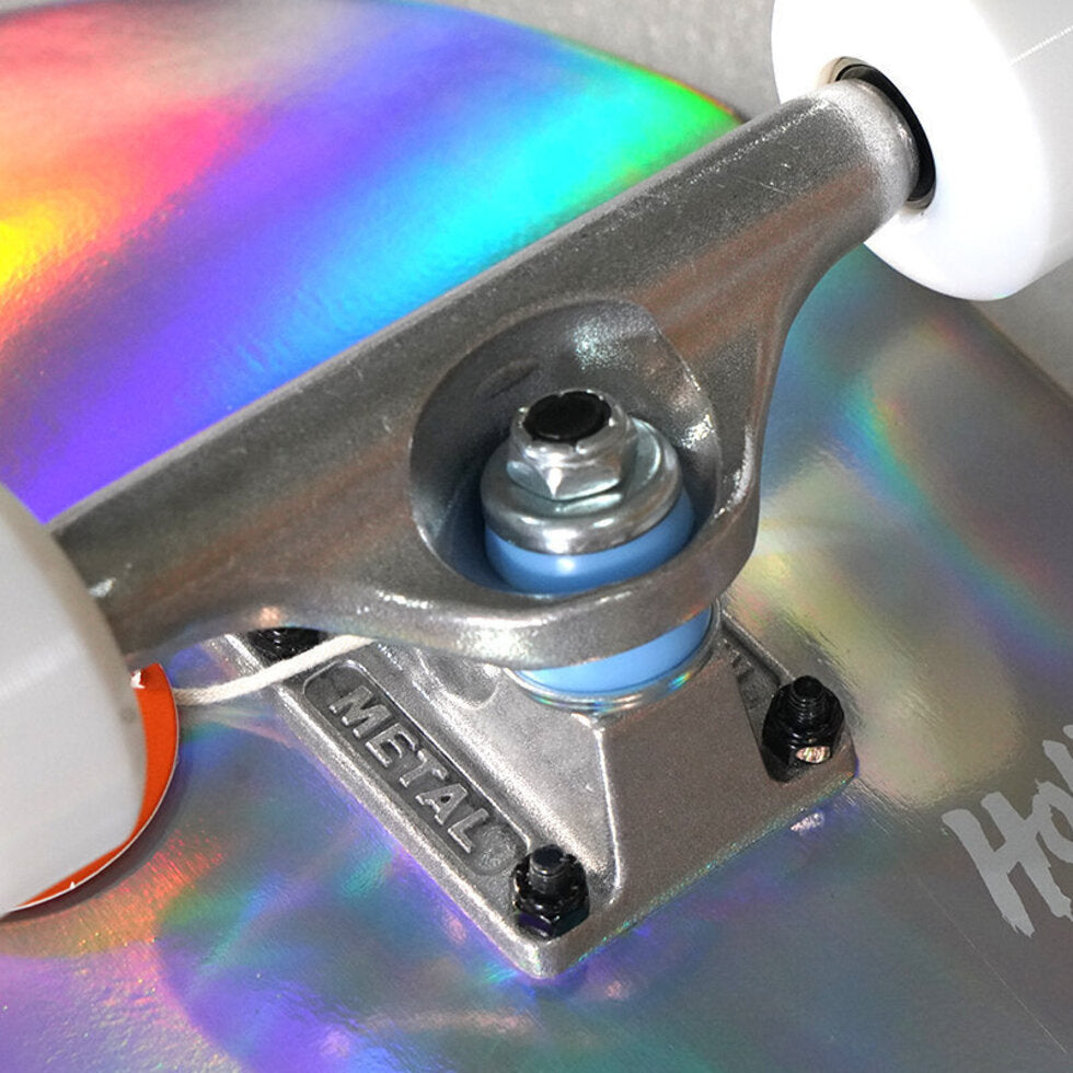 Close-up of a skateboard truck with colorful deck and 'Metal' branding.